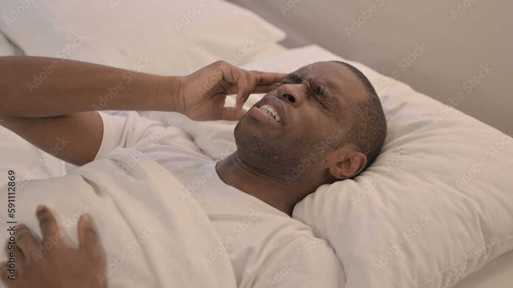 African Man with Headache Lying in Bed African Man with Headache Lying in Bed