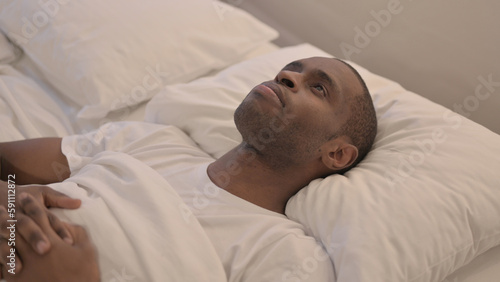 Brainstorming African Man Lying in Bed