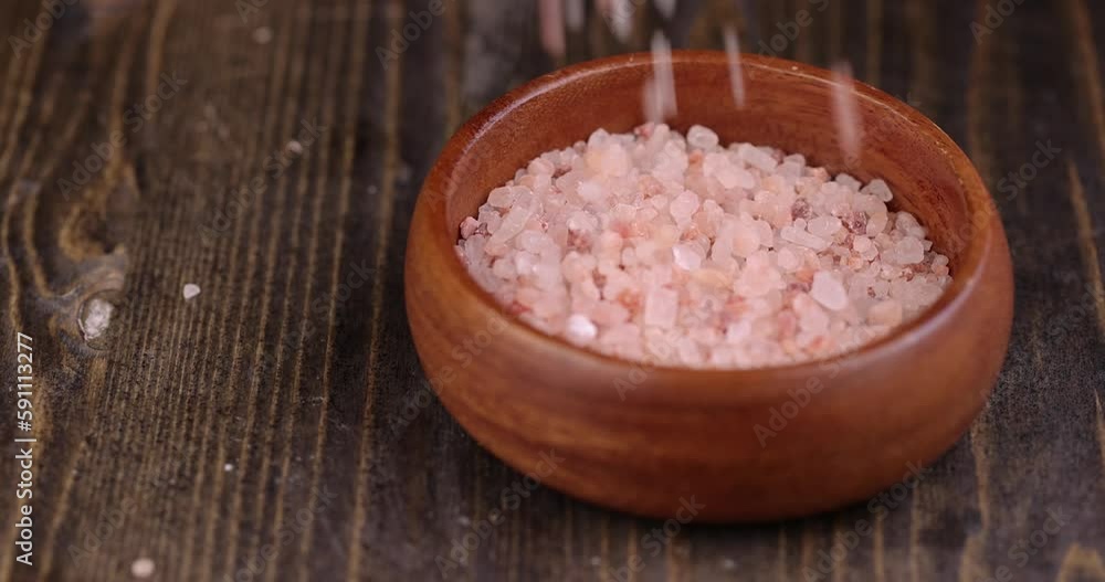 pour pink natural salt on the table, a beautiful unusual pink salt that is used in cooking pour pink natural salt on the table, a beautiful unusual pink salt that is used in cooking