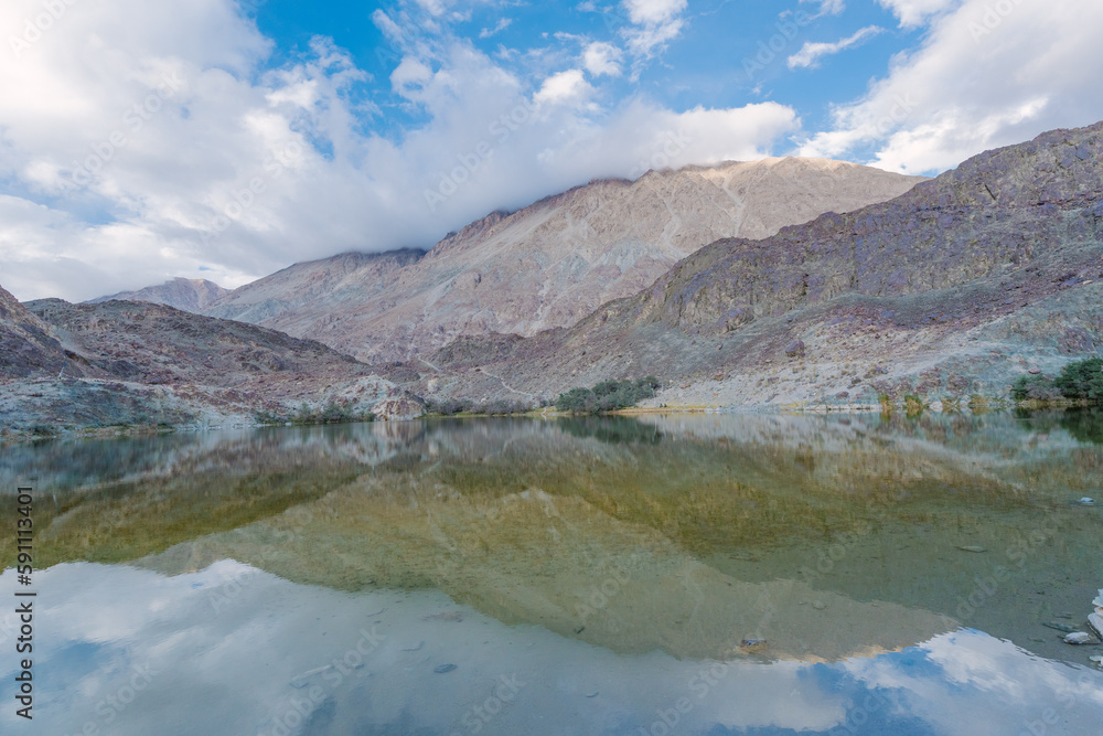 mountains, clouds and sky are reflected on the lake. Beautiful scenery at Yarab Tso valley - Leh Ladakh - India