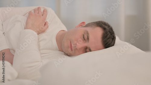 Young Man Sleeping in Bed on Side
