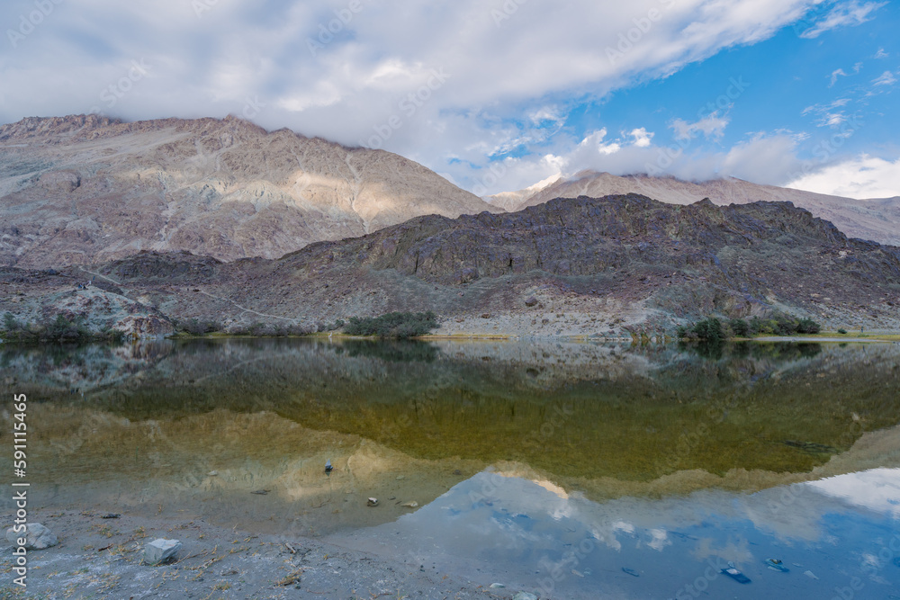 mountains, clouds and sky are reflected on the lake. Beautiful scenery at Yarab Tso valley - Leh Ladakh - India
