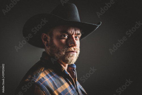 Rugged man in cowboy hat.  Studio session.