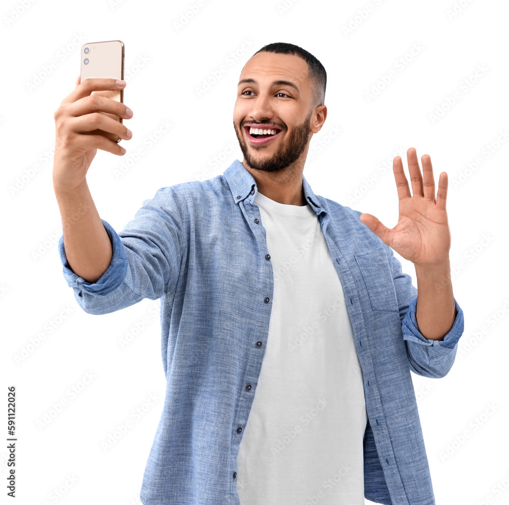Smiling young man taking selfie with smartphone on white background Smiling young man taking selfie with smartphone on white background