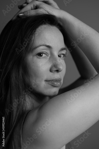 Black and white portrait of a woman without makeup. Natural female portrait with first wrinkles and plump lips