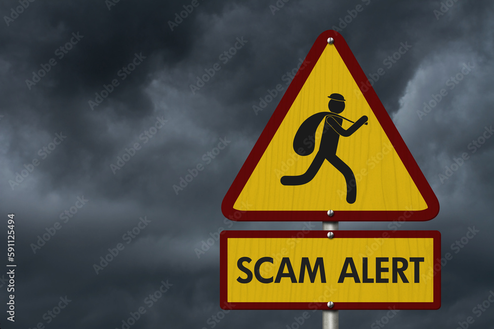 Scam Alert message on warning road sign on stormy sky Scam Alert message on warning road sign on stormy sky
