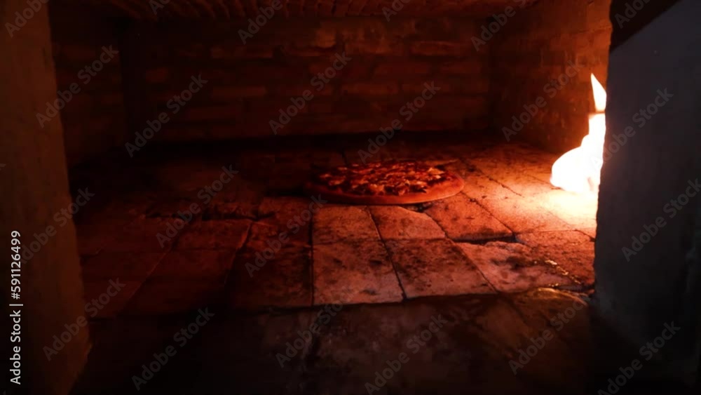 A slow motion shot with dolly in entering a brick oven with a shrimp and mushroom pizza cooking inside that is only lit by a blowtorch with fire A slow motion shot with dolly in entering a brick oven with a shrimp and mushroom pizza cooking inside that is only lit by a blowtorch with fire