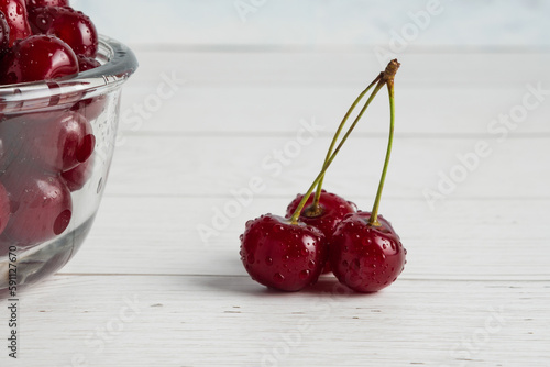 Fresh red cherries fruit on bowl on wooden background closeup, fresh ripe cherries in basket on wooden table, Fresh cherry on plate, sweet cherry top view, cherry or cherries fruits healthy dessert photo