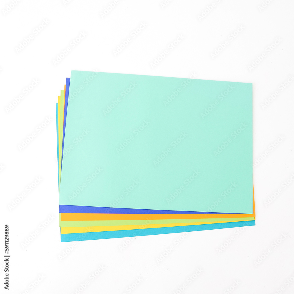 Multicolored paper on a white background. Flat lay, top view. There is space for text. The concept of office. Multicolored paper on a white background. Flat lay, top view. There is space for text. The concept of office.