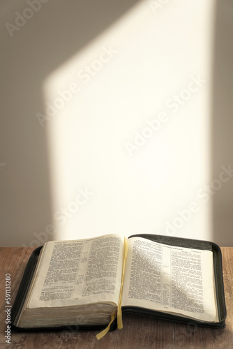 open bible on the table. light background, sunlight. enlightenment. faith, religion.