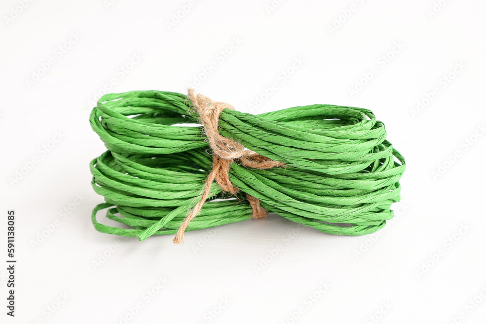 Green cord on a white background. Place for text and logo. The concept of decor, needlework.