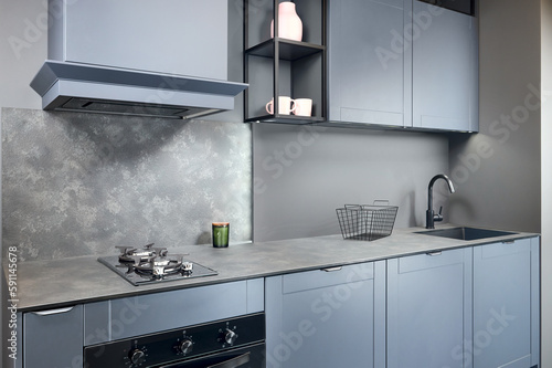 Blue grey contemporary kitchen linearlayout with hood two burners gas cooker hob oven and built in dishwasher machine and square black sink and tap compact high pressure laminate HPL countertop. photo