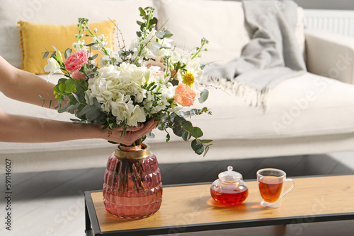 Bilde på lerret Woman arranging bouquet of beautiful flowers in vase indoors, closeup