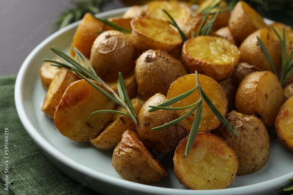 Delicious baked potatoes with rosemary on plate, closeup Delicious baked potatoes with rosemary on plate, closeup