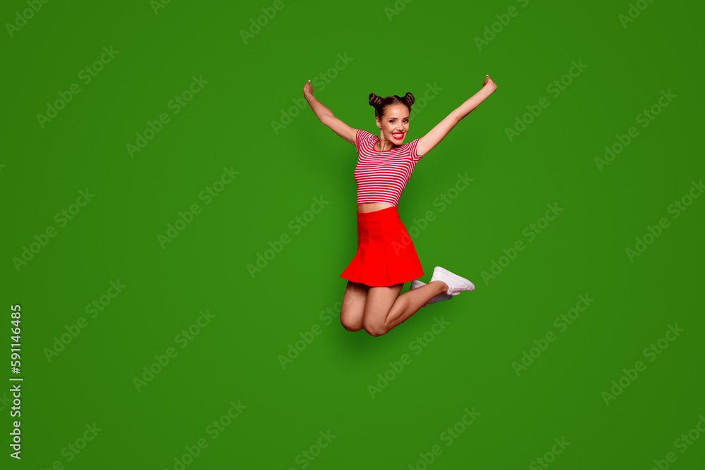 Full-length full-size view of jumping laughing and pretty woman dressed in colourful bright clothes isolated on red background Full-length full-size view of jumping laughing and pretty woman dressed in colourful bright clothes isolated on red background