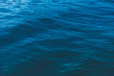 Abstract natural background. Azure sea water with ripples on the surface. Сopy space, shot from top