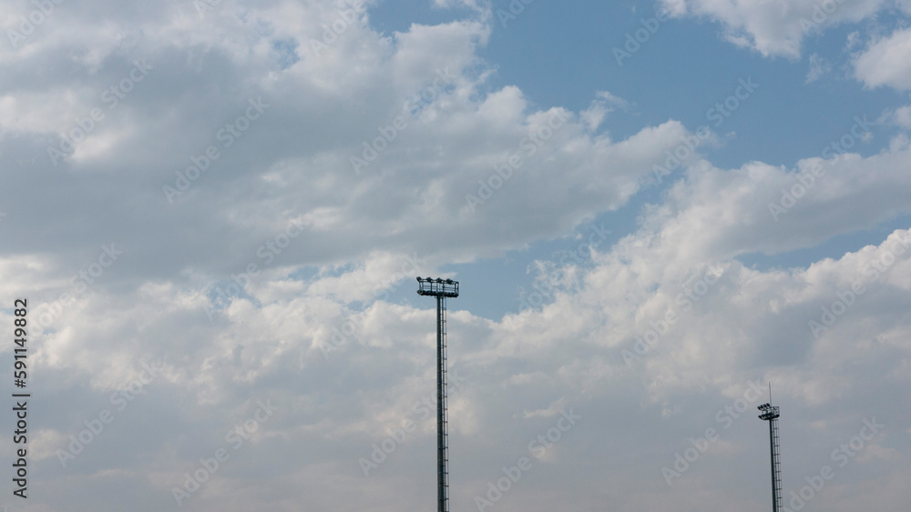 Postes de iluminación deportiva y cielo con nubes Postes de iluminación deportiva y cielo con nubes