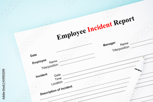 Fotografija The Template of an Employee incident report form document and and pen on blue background
