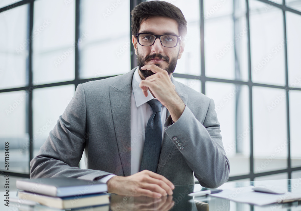 Image of a successful businessman rubbing his beard having an interesting idea while sitting in a modern office Image of a successful businessman rubbing his beard having an interesting idea while sitting in a modern office
