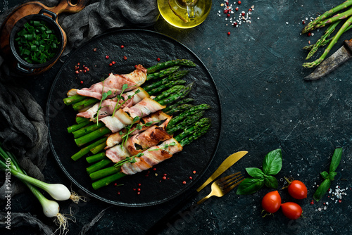Grilled green asparagus wrapped with bacon. Healthy food. On a stone background. Top view.