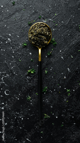 Black caviar in a spoon. Macro photo of caviar. On a concrete background. Top view.