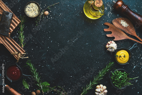 Cooking background. Spices, vegetables and herbs. On a black stone background. Top view.