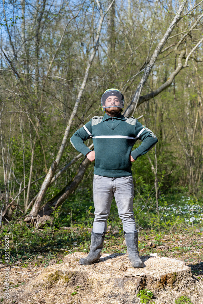 jeune garde forestier fier en forêt sur une souche 