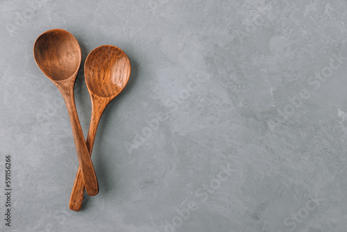 Wooden spoons. Two wooden spoons on gray concrete stone background, kitchen concept. photo
