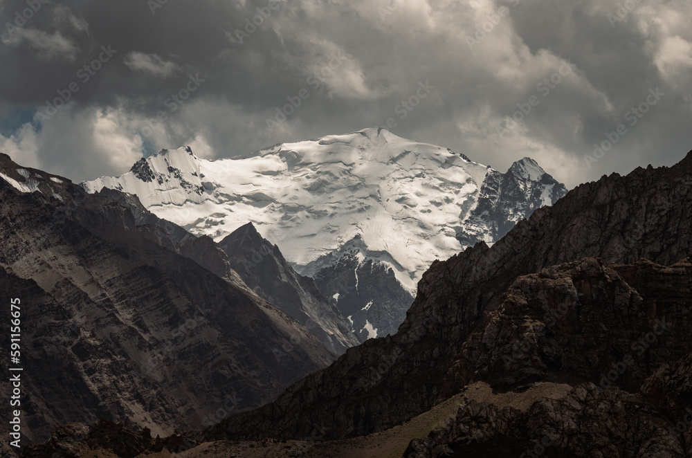 Glaciers on the massive mountain peaks of the Turkestan Ridge. In Kyrgyzstan. Above the Orta-Chashma river valley.