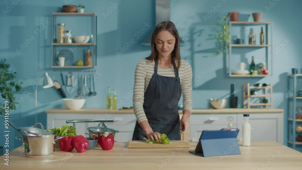 Smiling Woman Preparing Vegetable Meal and Watch Recipes on Tablets in Internet.Vegetarian Woman Cooking Healthy Food Salad Using Cookbook. Lifestyle, On-line Recipes, Food Delivery Services Concept. Smiling Woman Preparing Vegetable Meal and Watch Recipes on Tablets in Internet.Vegetarian Woman Cooking Healthy Food Salad Using Cookbook. Lifestyle, On-line Recipes, Food Delivery Services Concept.