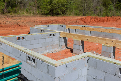 Construction site with cement blocks that will be used for walls holding up house foundation.
