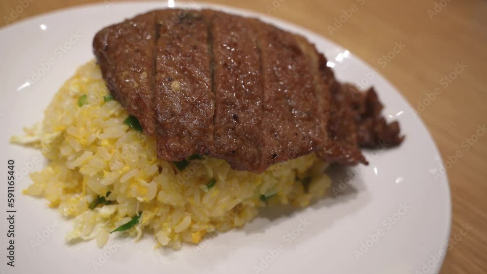 Close-up view of the pork chop egg fried rice on the plate. Close-up view of the pork chop egg fried rice on the plate.