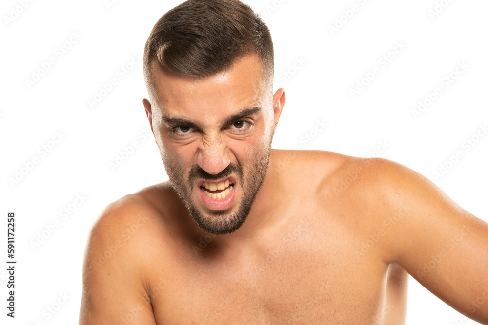 portrait of young angry shirtless man with beard, screaming on a white background portrait of young angry shirtless man with beard, screaming on a white background