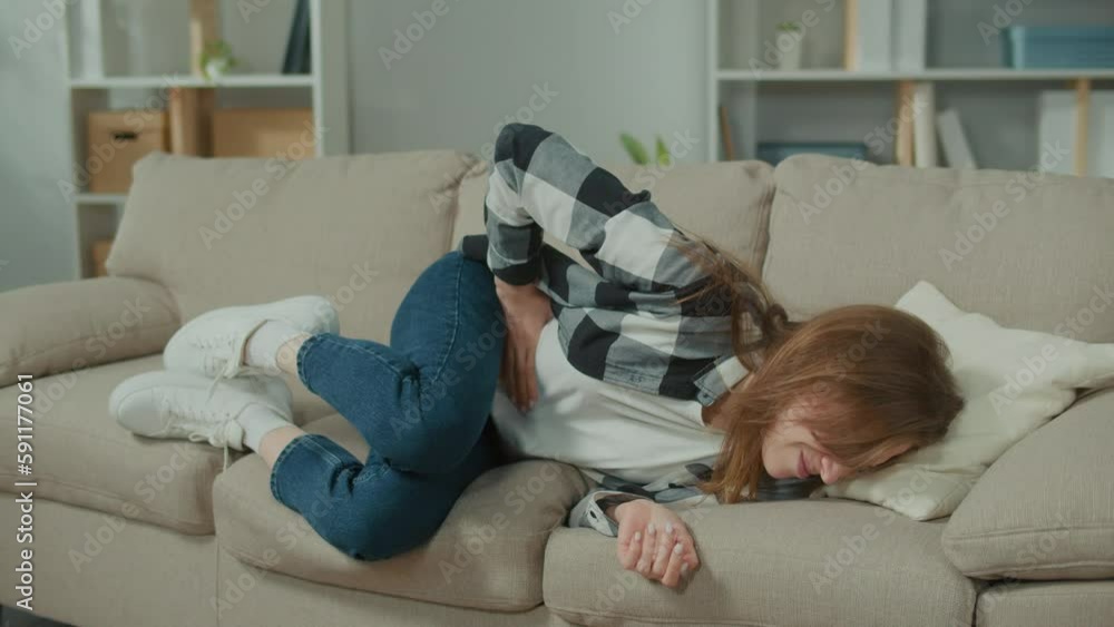 Upset Woman Go on the Sofa With Stomach Ache. Woman Feeling Abdominal, Ulcer in her Tummy, or Menstrual Pain at Home. Gastritis, Diarrhea, Pancreatitis and Painful Periods Concept. Upset Woman Go on the Sofa With Stomach Ache. Woman Feeling Abdominal, Ulcer in her Tummy, or Menstrual Pain at Home. Gastritis, Diarrhea, Pancreatitis and Painful Periods Concept.