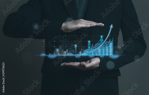 Business invest growth success concept. Man in black suit show hologram technology graph, chart, diagram on hands. Stock and trade. Sales forecasting to analysis profit and loss of the company