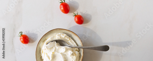 bowl with mascarpone and cherry tomatoes on light table