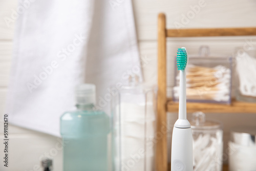 Modern sonic or electric toothbrush with charger in the bathroom. The concept of professional oral care and healthy teeth. Place for text. Close-up. Minimal design. Fresh breath. Healthy teeth.