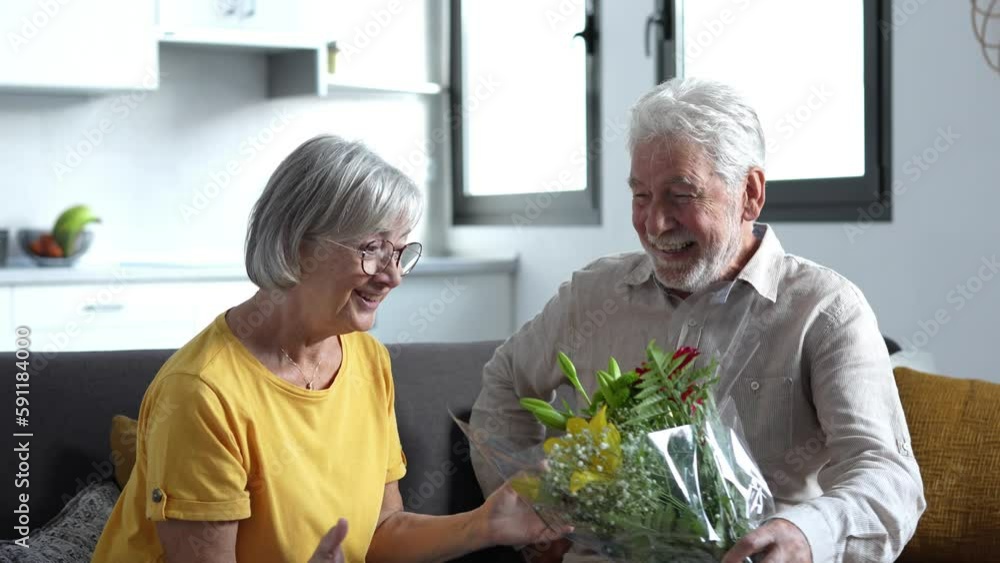 Old man giving flowers at his wife sitting on the sofa at home for the San Valentines’ day. Pensioners enjoying surprise together. In love people having fun.
Old man giving flowers at his wife sitting on the sofa at home for the San Valentines’ day. Pensioners enjoying surprise together. In love people having fun.