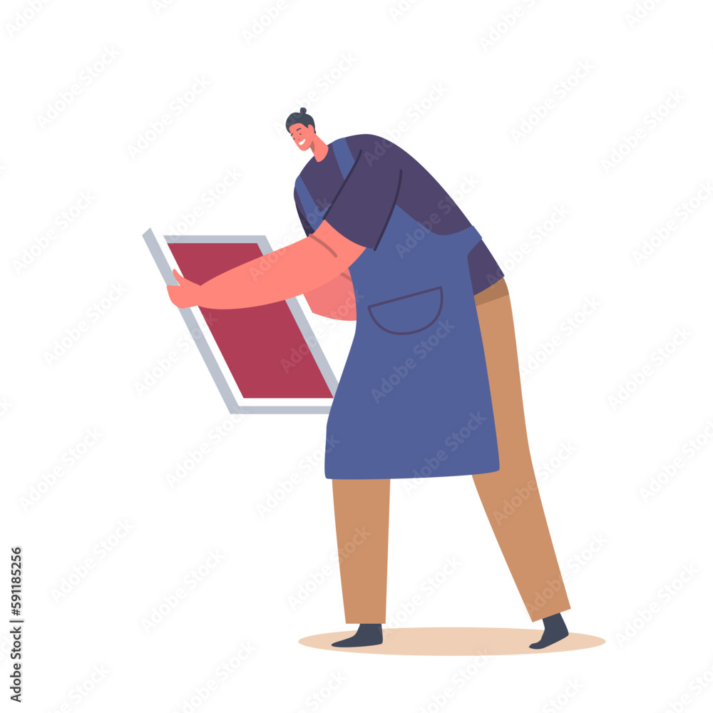 Man In Apron Hold Screen For Silk Printing On T-shirt. The Image Showcases Process Of Printing Designs On Clothing Man In Apron Hold Screen For Silk Printing On T-shirt. The Image Showcases Process Of Printing Designs On Clothing