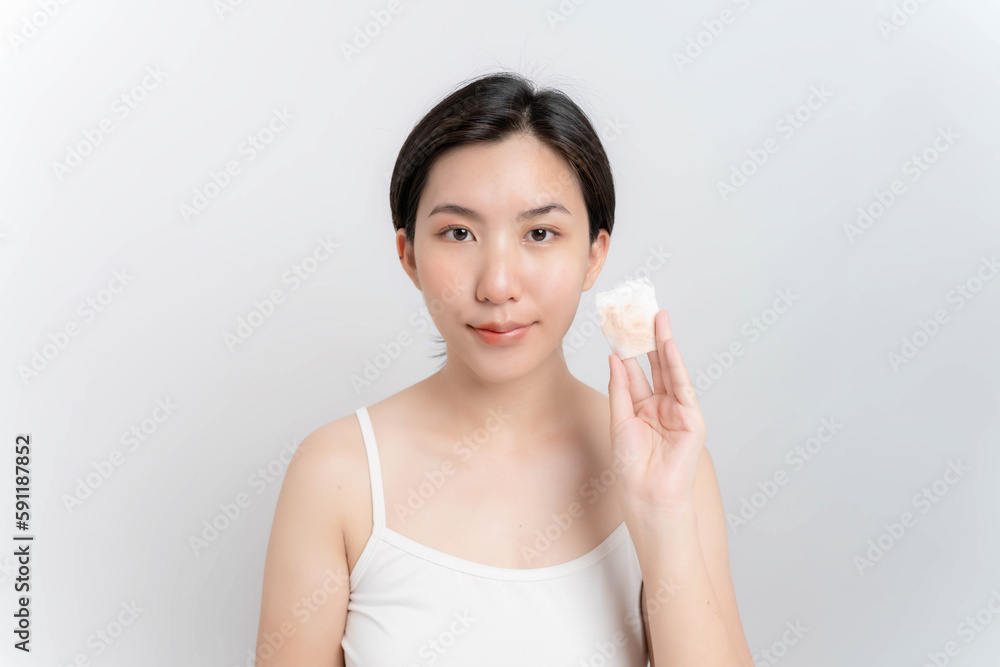 Asian woman wiping her face with cleansing Asian woman wiping her face with cleansing
