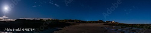 A moonlit panoramic view of the night sky over the beach at Beadnell   Northumberland in the United Kingdom