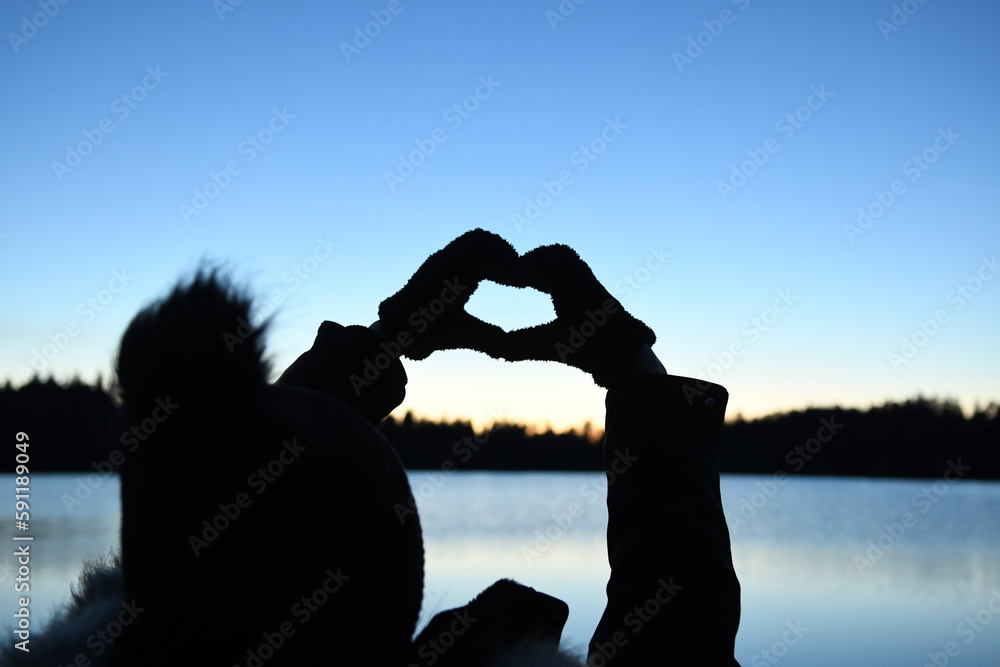 Silhouette de deux personnes et des mains en forme de coeur - obrazy, fototapety, plakaty 