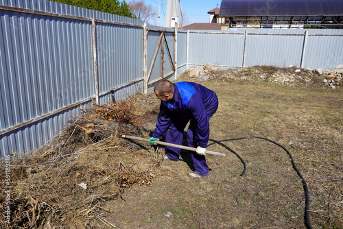 A man works in a vegetable garden in early spring.