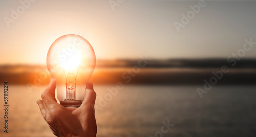 Leuchtende Glühbirne in einer Hand