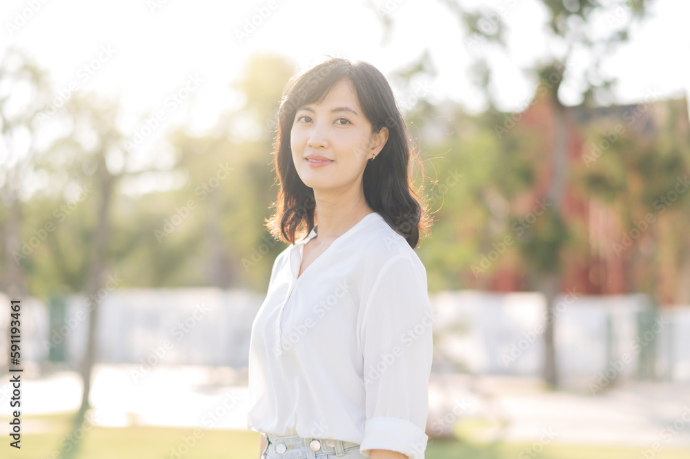 Portrait young beautiful asian woman with happy smile around outdoor park in sunny summer day Portrait young beautiful asian woman with happy smile around outdoor park in sunny summer day