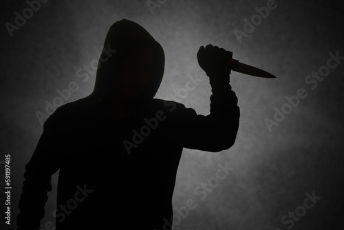Tableau sur toile Mysterious man wearing black hoodie holding a knife to stab someone