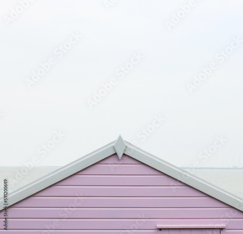 Old English beach hut in pink and white with copy space