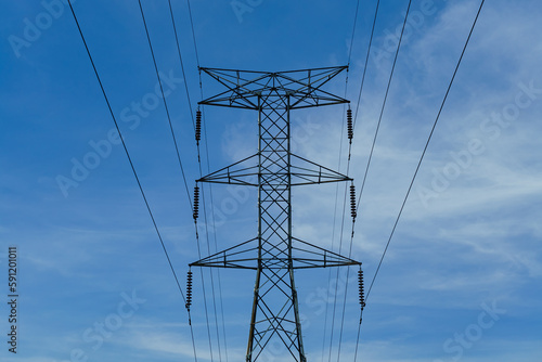 Electrical tower against a blue cloudy sky