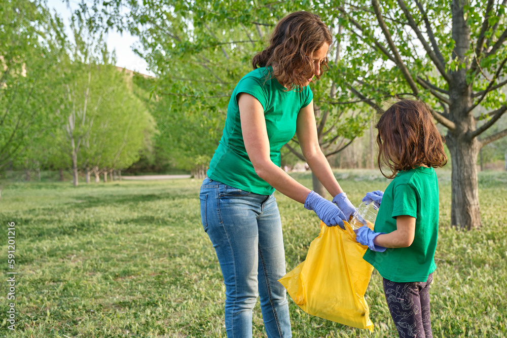 Fototapeta premium a girl with her mother collecting plastic from the field to take care of nature