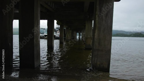 Wallpaper Mural looking down the pillars under Pier on the beach looking out on the water Torontodigital.ca